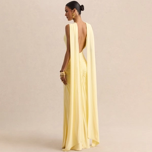 Detail of light yellow backless maxi dress featuring pleated fabric and long cape straps