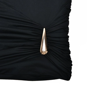 Détail du tissu tricoté noir froncé avec une boucle métallique dorée en forme de goutte