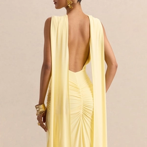 Detail of light yellow backless dress with elegant long ribbons and ruched back design