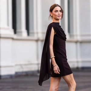 Detail of elegant dark brown mini dress featuring a unique draped shoulder cape design