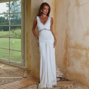 Close-up of elegant white sleeveless dress featuring lace waist splicing and pleated knot detail
