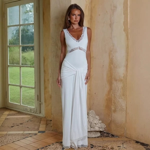 Detail of elegant white V-neck dress featuring delicate lace trim and waist pleat texture