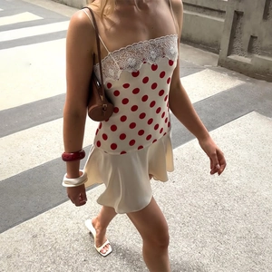Detailansicht eines weißen Satin-Polka-Dot-Kleides mit Spitzenbesatz und Trägern