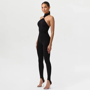 Detail of black halter neck jumpsuit featuring a silver metal ring and stirrup leggings