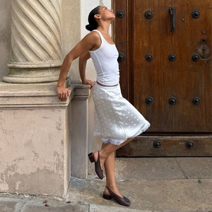 Dettaglio della gonna in seta bianca a pois con pizzo delicato e stile vintage