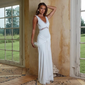 Detail of elegant white sleeveless dress featuring deep V-neck and lace trim accents