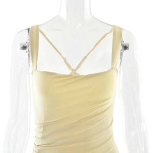 Detail of light yellow ruched dress with thin straps and elegant back crossover ties