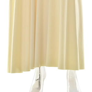 Detail view of cream pleated dress hem with elegant draping and smooth fabric texture