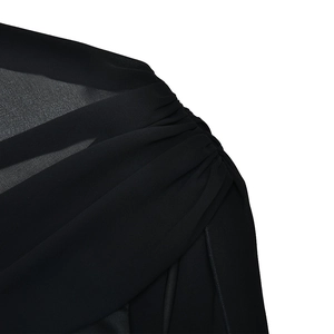 Detail of elegant black sleeveless dress featuring sheer chiffon pleats and fine stitching
