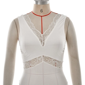 Close-up of elegant white sleeveless dress with intricate lace detailing and deep V-neck