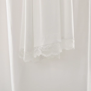 Detailed view of elegant white lace trim on the hem of the bodycon evening dress