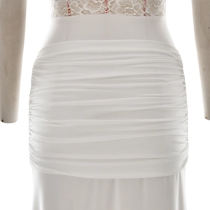 Detail of elegant white bodycon dress featuring delicate lace inserts and ruched waist texture