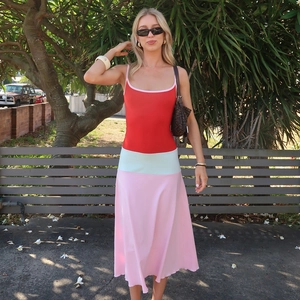 Close-up of a three-color patchwork bodycon dress with red, green, and pink fabric details