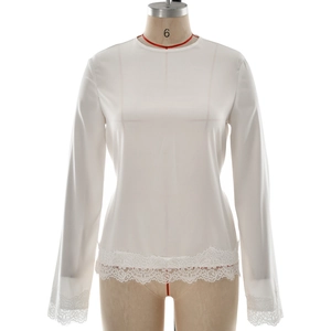 Elegant white long sleeve crewneck blouse with delicate lace hem and satin finish texture
