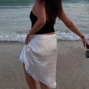 Gonna midi elegante in raso a pois bianchi con bordo in pizzo per un look retrò chic