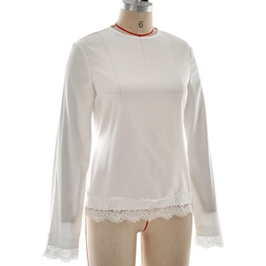 Close-up of white satin blouse with delicate eyelash lace trim on sleeves and hemline