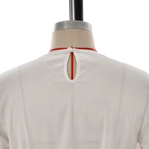 Detail of white long sleeve top featuring a keyhole back closure with a mushroom button