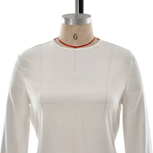 Detail of white long sleeve blouse showing round neckline and silky fabric on mannequin