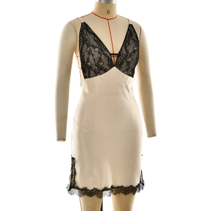 Close-up of beige satin dress featuring delicate black lace trim and deep V-neckline