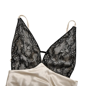 Detail of elegant black floral lace stitching on champagne silk satin V-neck dress