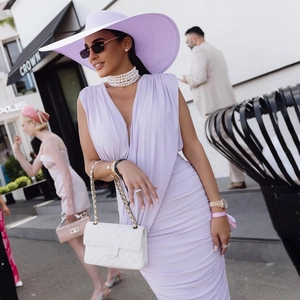 Detail of lavender V-neck bodycon dress with ruching and luxury white quilted chain bag