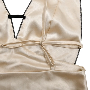 Close-up detail of champagne satin dress with deep V-neck and delicate lace stitching
