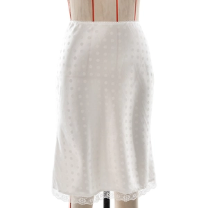 Dettaglio gonna midi bianca con jacquard a pois e bordo in pizzo floreale sull'orlo