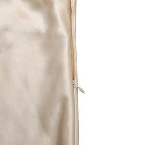 Detail of hidden zipper and smooth champagne satin fabric on an elegant slim fit dress