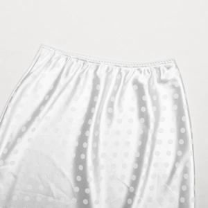Dettaglio della vita di una gonna in raso bianco con jacquard a pois e pizzo
