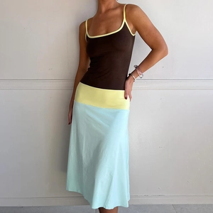 Detail of color-block dress showing the contrast between yellow waist and light blue skirt