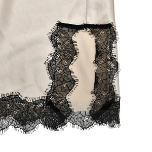 Detail of champagne satin dress with exquisite black eyelash lace trim on the hem