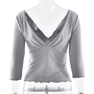 Detail of light grey slim fit top with V-neckline, lettuce hem, and ruched texture