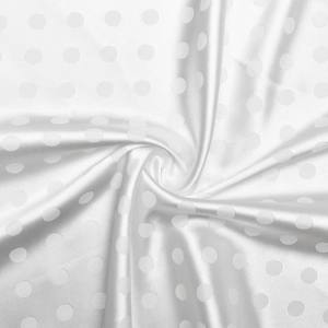 Dettaglio del tessuto di raso bianco lucido con eleganti motivi jacquard a pois