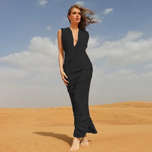 Detail view of elegant black V-neck maxi dress with stylish pleated texture in a desert setting