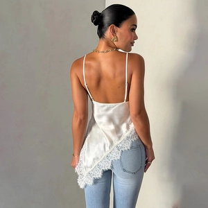 White satin slip top with lace trim and open back design paired with denim jeans