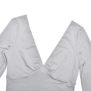 Detail view of deep V-neck and ruched waist design on a grey long-sleeved shirt