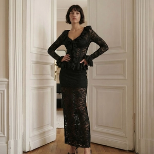 Close-up of the black lace texture and ruffle details on the V-neck long sleeve top and skirt