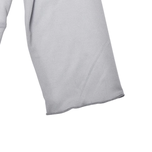 Close-up of light gray knitted fabric texture with fine stitching on the sleeve edge
