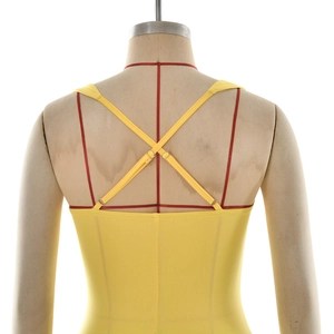 Detail of yellow backless dress with adjustable minimalist cross straps and metal buckles