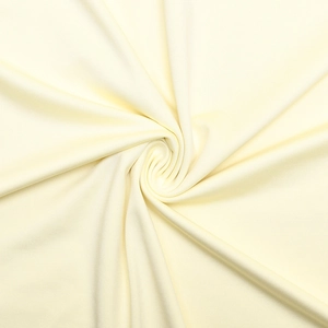 Detailed view of cream knitted dress fabric showing smooth texture and elegant drape