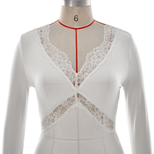 Close-up of white long sleeve top with deep V-neck lace patchwork and slim fit design