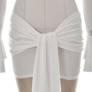 Detailed view of white wrap skirt with adjustable front tie lace and pleated texture