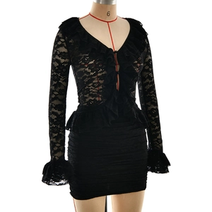 Detailed close-up of black lace V-neck top with ruffled edges and sheer floral texture