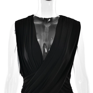 Detail view of the deep V-neckline and elegant draped pleats on the black sleeveless dress