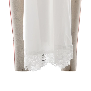 Detail shot of delicate white lace hem and fine fabric texture on a slim-fit dress