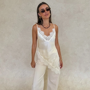 Detailed view of the elegant lace-trimmed V-neckline and asymmetrical hemline on silk camisole