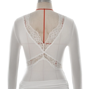 Detail of elegant white lace cross-straps and V-neck back on a slim-fit dress