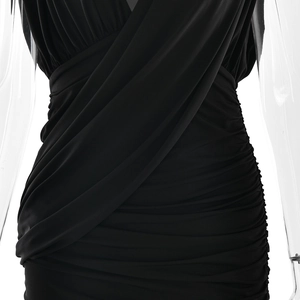 Detailed macro view of the elegant black ruched fabric and draped design of the bodycon dress