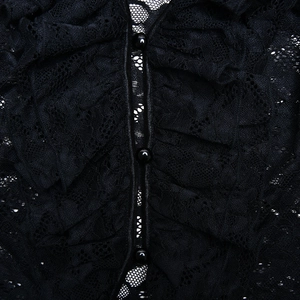 Detailed macro view of black floral lace fabric with ruffles and polished buttons