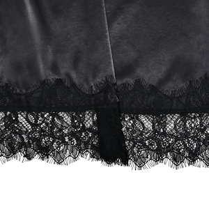 Detailed view of black satin fabric hem with intricate eyelash lace trim and fine stitching
